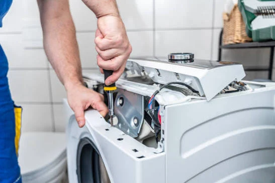 Close-up of a technician repairing a washing machine control panel