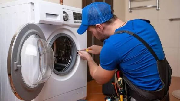Technician inspecting a washing machine door